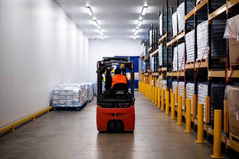 Someone driving a small forklift through the Prima Cheese factory