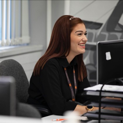 An office worked smiling at her desk